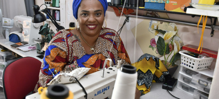 Além de beneficiária, Jaqueline Terra também aceita a moeda social no seu negócio: ela faz roupas de matriz africana