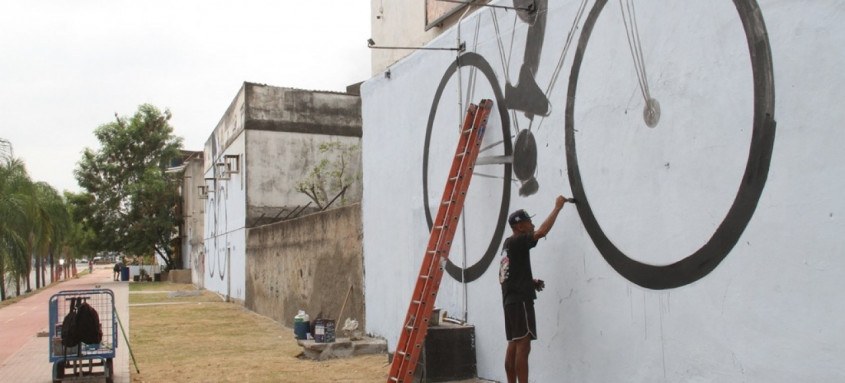 Novo painel, que fica próximo de um trecho da ciclovia do MUVI, mostra pessoas em escala gigante andando de patins, bicicleta, skate e patinete, em diversas cores