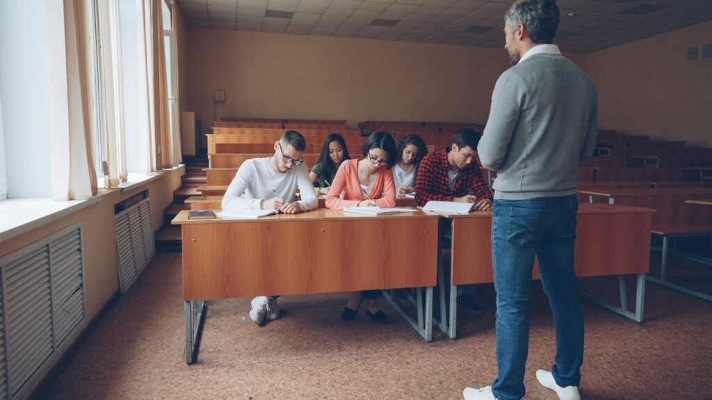 Estudantes em sala de aula durante atividade de escrita e preparação para prova