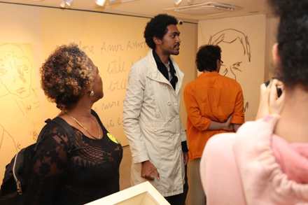 Visitantes observam desenhos e obras em ambiente expositivo dedicado ao ator Paulo César Peréio